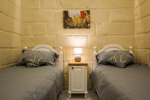 ŻabbarTa' Ġilard - Lovely Renovated Holiday Home的两张睡床彼此相邻,位于一个房间里