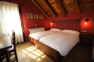 圣克鲁斯德拉塞罗斯Hotel Rural El Mirador de los Pirineos的一间卧室设有一张带红色墙壁的大床