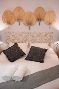 塞维利亚Apartamento Alma Sevilla的卧室配有白色的床铺和木制床头板