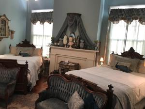 哥伦布谢多洛恩住宿加早餐旅馆的一间卧室设有两张床、一把椅子和窗户。