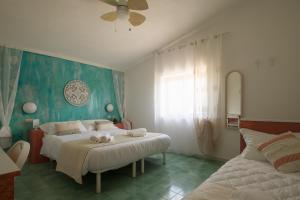 坎普码头Hotel Punto Verde的一间卧室配有两张床和吊扇