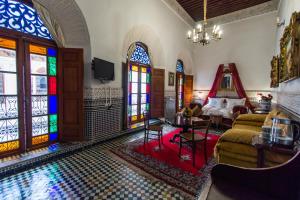 非斯Riad Damia Suite &Spa的一间带彩色玻璃窗和游泳池的客厅