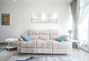 普特拉贾亚zara1881 muslim homestay@putrajaya的白色客厅配有白色沙发及蓝色枕头