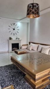 纳祖尔Nador Khattabi 2-18的客厅配有沙发和墙上的时钟