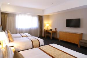 台南台南富信大饭店的酒店客房设有两张床和一台平面电视。