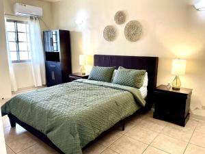 塔穆宁beautiful 4 bedroom tumon house的一间卧室配有一张带2个床头柜和2盏灯的床。