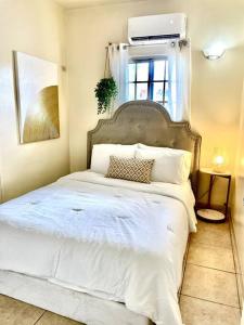 塔穆宁beautiful 4 bedroom tumon house的卧室配有一张大白色床和窗户