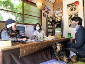 镰仓市岐阜伊洛多利宾馆的一群人和一只狗坐在桌子上