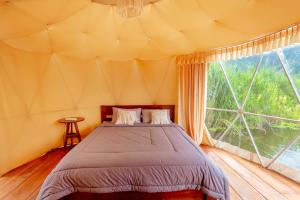 金塔马尼Jempana View的一个带大窗户的帐篷内一间卧室,配有一张床