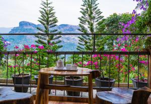 蒙纳Sceva's Garden Home的阳台配有桌椅和鲜花。