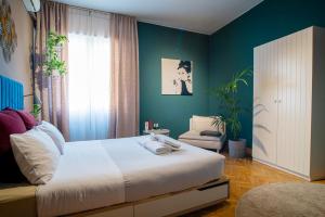 特雷维索Terzopiano的卧室配有白色的床和绿色的墙壁