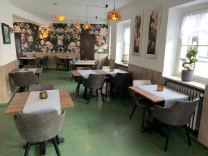 埃恩鲁赫Garni Hotel im Fachwerkhof的餐厅墙上挂着桌椅和鲜花
