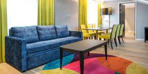 奥斯陆松恩酒店的客厅配有蓝色的沙发和桌子