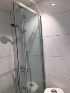 斯塔韦恩Koselig leilighet sentralt i Stavern的一间带卫生间的浴室内的玻璃淋浴间