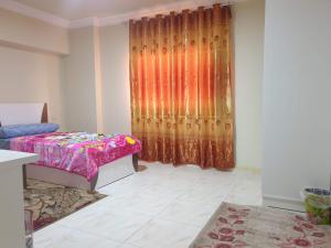 十月六日城سكن للذكور فقط - Sakan Male Only的卧室配有床和窗帘