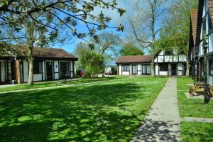 海尔Tudor Cottage Hayle - a Family & Pooch Favourite的一座带长凳的建筑旁边的绿色庭院