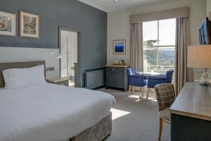 巴斯Lansdown Grove Hotel的配有一张床、一张桌子和一张桌子的酒店客房