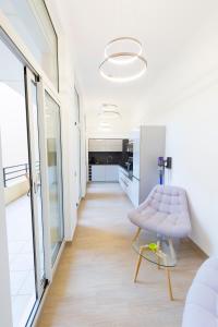 芒通JARDIN DES MUSES - 2 PIECES - PARKING Carré d'or Menton的白色的房间,配有粉红色的椅子和走廊