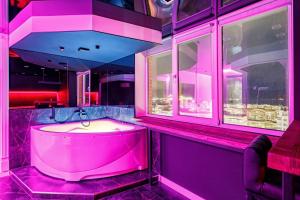 克拉斯诺达尔HouseX的粉红色的浴室设有浴缸和窗户。