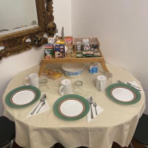 卡普里亚泰圣杰尔瓦肖B&B Family First的一张桌子,上面有绿色和白色的盘子和餐具