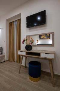 卡拉马塔Kalypso Apartments的客厅配有一张桌子,墙上配有电视