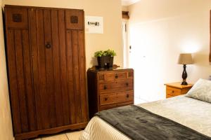 斯特尔拜Elize Cottage的一间卧室配有木制橱柜和一张床