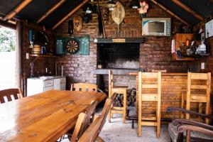 斯特尔拜Elize Cottage的一间设有木桌和砖墙的用餐室