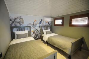 阿奇亚卡Alp Suites Mandalin的一间卧室设有两张床,并拥有动物壁画