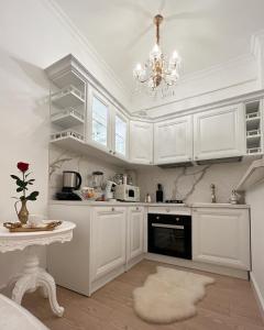 蒂米什瓦拉FSF Boutique Apartament的白色的厨房配有白色橱柜和吊灯