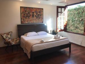巴西利亚Casa da 17 - Lago Sul的一间卧室配有一张大床和一把椅子