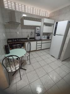 福塔莱萨Sua casa fora de casa的厨房配有桌子和冰箱