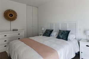 拉盖里尼耶尔Superbe appartement neuf face plage sur l ile de Noirmoutier的白色卧室配有一张带两个枕头的大床