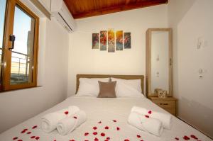 基萨莫斯Trouli Rokka House的一间卧室,床上有红色玫瑰