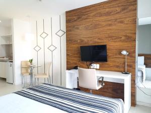 巴西利亚费欧逊赫普拉斯酒店的一间卧室配有一张带书桌的床和一台电视。