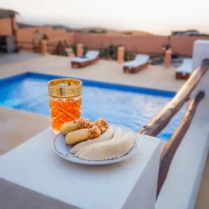 艾西拉Villa avec piscine Asilah, terrain de foot privative的两只热狗和一罐蜂蜜的盘子