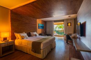 阿奎拉兹卡梅尔查姆度假村的一间卧室配有一张大床和电视