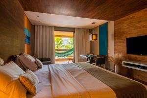 阿奎拉兹卡梅尔查姆度假村的一间卧室设有一张大床和一台平面电视。