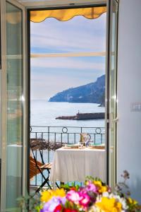 阿马尔菲Casa La Voce del Mare的一张桌子,从窗口可欣赏到海景
