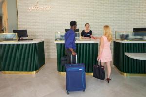 布里斯托Leonardo Hotel Bristol City的一名男子和一名女子带着行李站在柜台上
