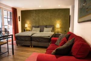 采尔马特Village Apartment with Matterhorn View的一间卧室配有一张床和一张红色的沙发