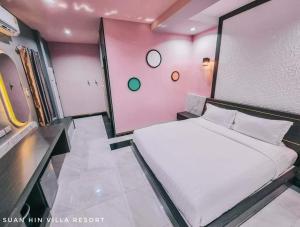 Ban Chotสวนหินวิลล่า รีสอร์ท的一间小卧室,配有白色的床和粉红色的墙壁