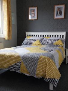 卡纳芬89 Lower Lakeside - Glan Gwna Holiday Park的一间卧室配有一张黄色和白色的被子。
