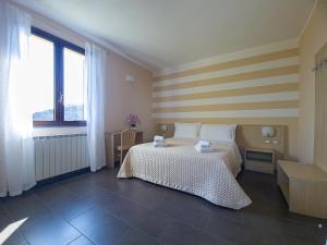 斯培西亚Agriturismo La Pietra的一间卧室配有一张带条纹墙的床