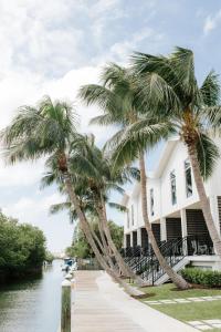 基韦斯特The Capitana Key West的一条棕榈树环绕着河流的白色建筑