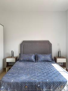 瓜伊马延complejo 25 de mayo的一张带蓝色棉被和蓝色枕头的床