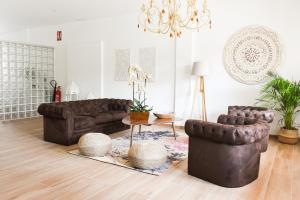 坎巴多斯Villaprado的客厅配有棕色皮革家具和吊灯。