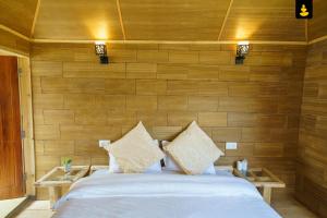 西姆拉LivingStone Shimla Jungle Stay的一间卧室配有一张带木墙的大床