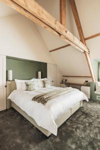 布鲁日Raphaëlles Boutique b&b的一间卧室配有一张白色大床和绿色床头板