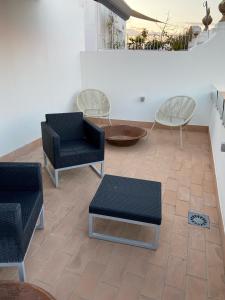 塞维利亚CASA NAIA Santa Rufina 7的一间设有两把椅子和一张桌子及椅子的房间
