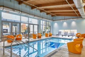 阿什本杜勒斯机场北雅乐轩酒店的一个带橙色椅子的室内游泳池和游泳池
